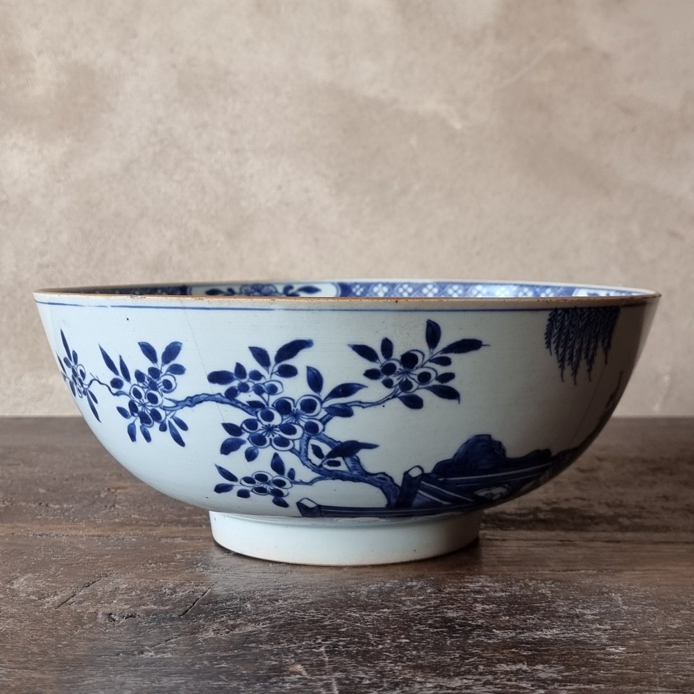 An 18th-century circular Chinese export porcelain punch bowl decorated with hand-painted blue figures under a willow tree. View VI