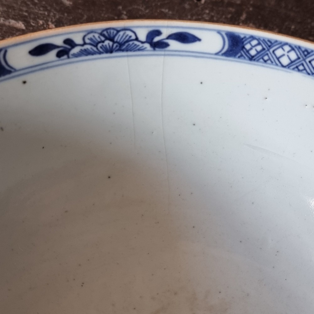 An 18th-century circular Chinese export porcelain punch bowl decorated with hand-painted blue figures under a willow tree. View X