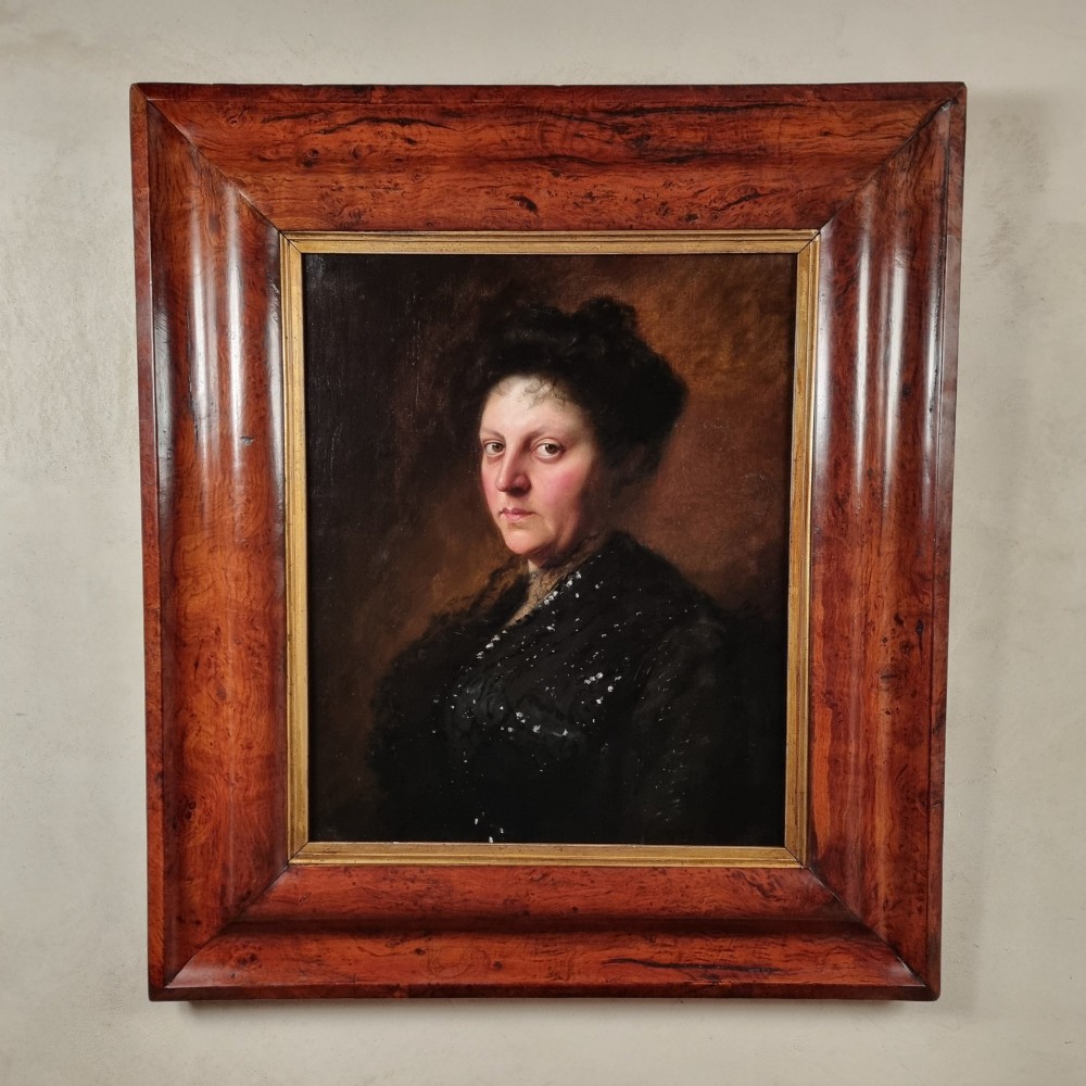 An Edwardian oil portrait of a lady framed in a wide burr wood moulding with a gilded inner border.