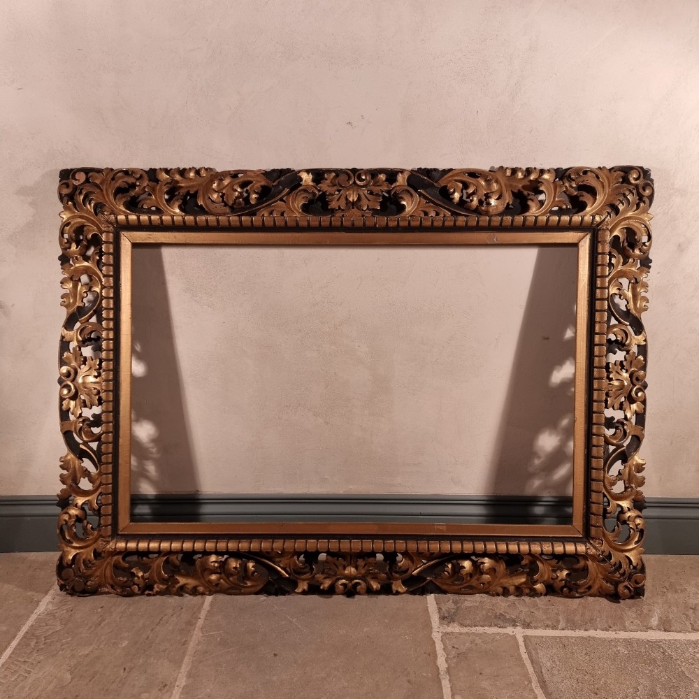 A large nineteenth-century rectangular giltwood frame featuring elaborate openwork acanthus leaf carvings and a gadrooned inner border.