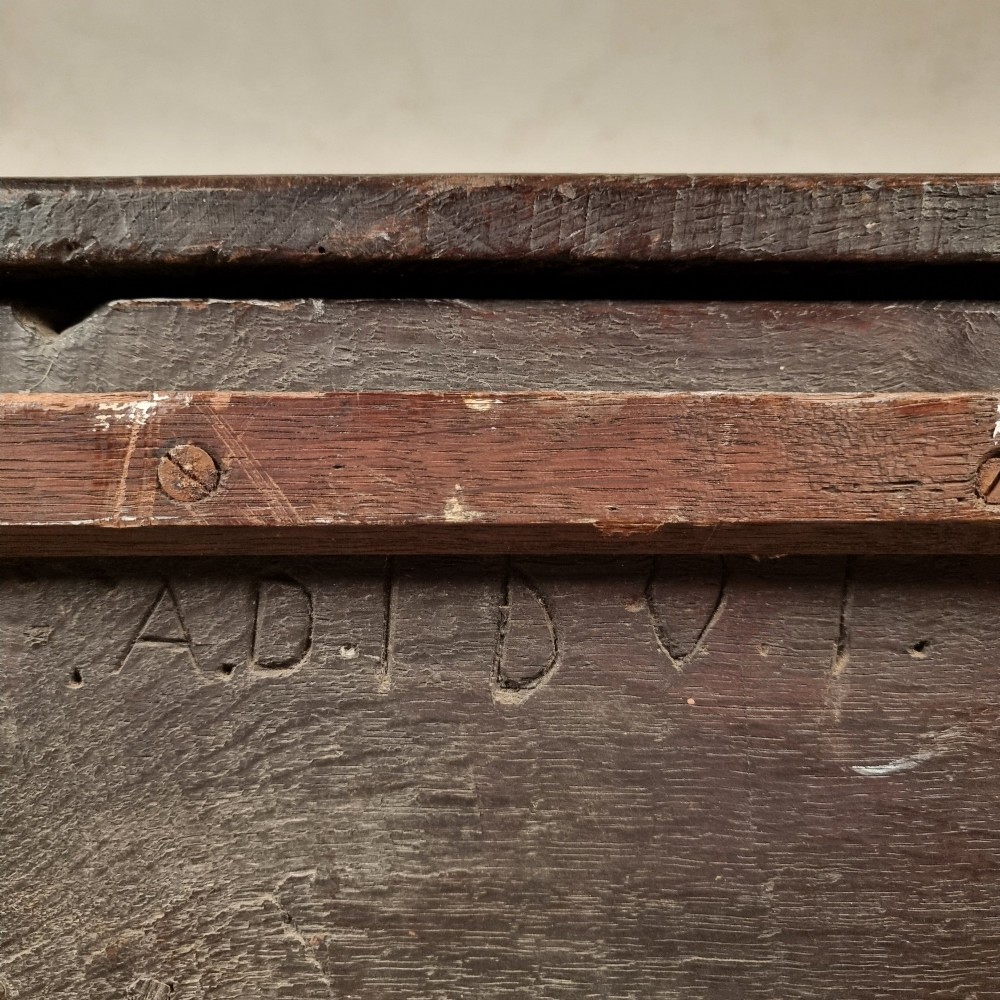 A dark carved oak early 17th-century coffer featuring decorated scrollwork panels and a central iron lockplate. View XIV