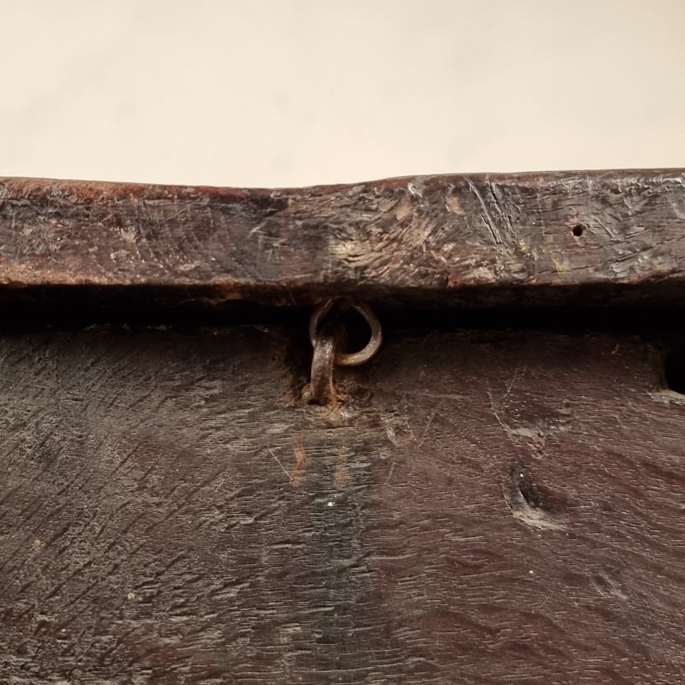 A dark carved oak early 17th-century coffer featuring decorated scrollwork panels and a central iron lockplate. View XV