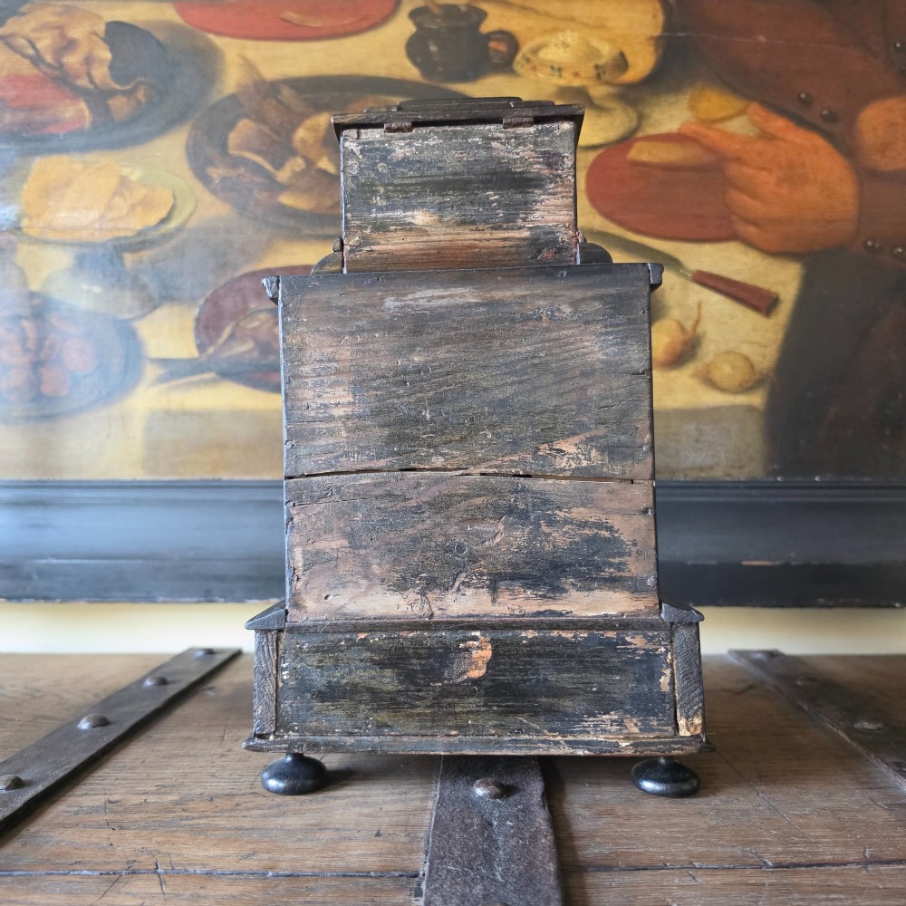 A tiered 18th-century walnut jewellery cabinet featuring ornate silvered metal hinges, a central latch mechanism, a lower drawer, and turned bun feet. View X