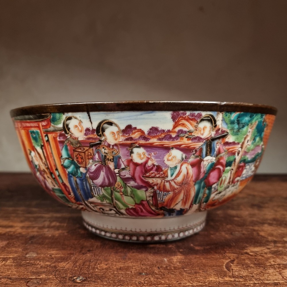 A 19th-century Chinese porcelain bowl featuring hand-painted polychrome figural scenes and a metal-bound rim. View V