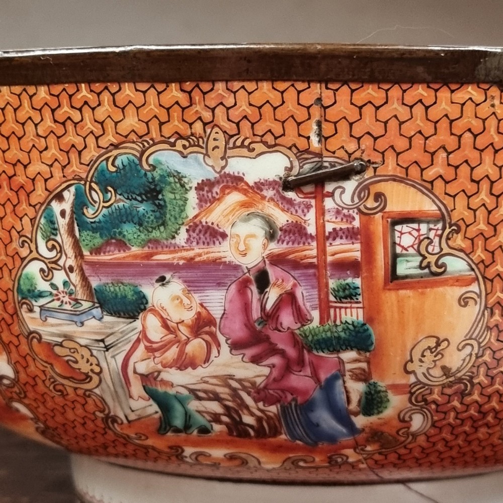 A 19th-century Chinese porcelain bowl featuring hand-painted polychrome figural scenes and a metal-bound rim. View X