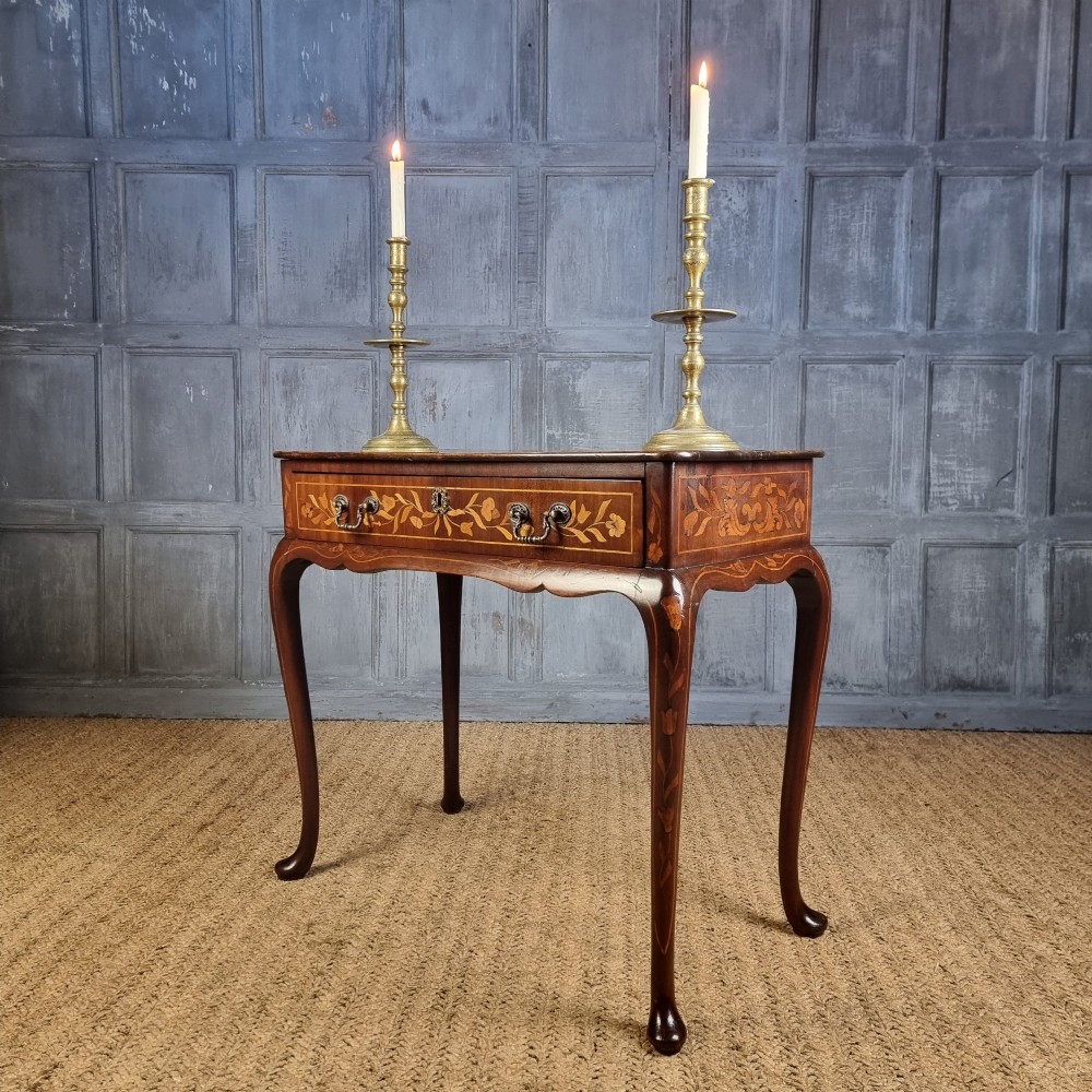 An 18th-century warm brown timber centre table with intricate floral marquetry inlay across the single drawer front, apron, and slender cabriole legs. View IV