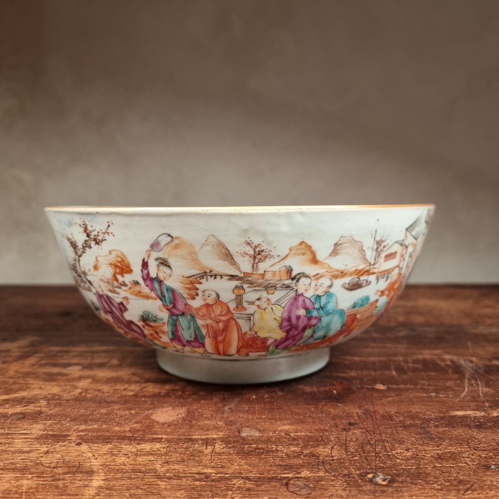 A 19th-century Chinese porcelain bowl hand-painted with polychrome enamels depicting figures in a garden landscape against an off-white background. View V