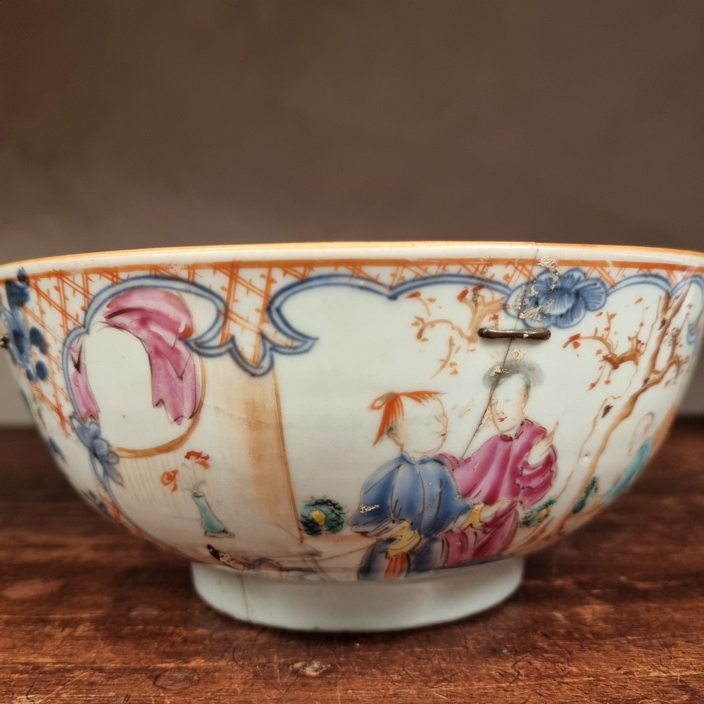 A 19th-century footed Chinese porcelain bowl featuring hand-painted figurative scenes in polychrome enamels with red lattice borders. View V