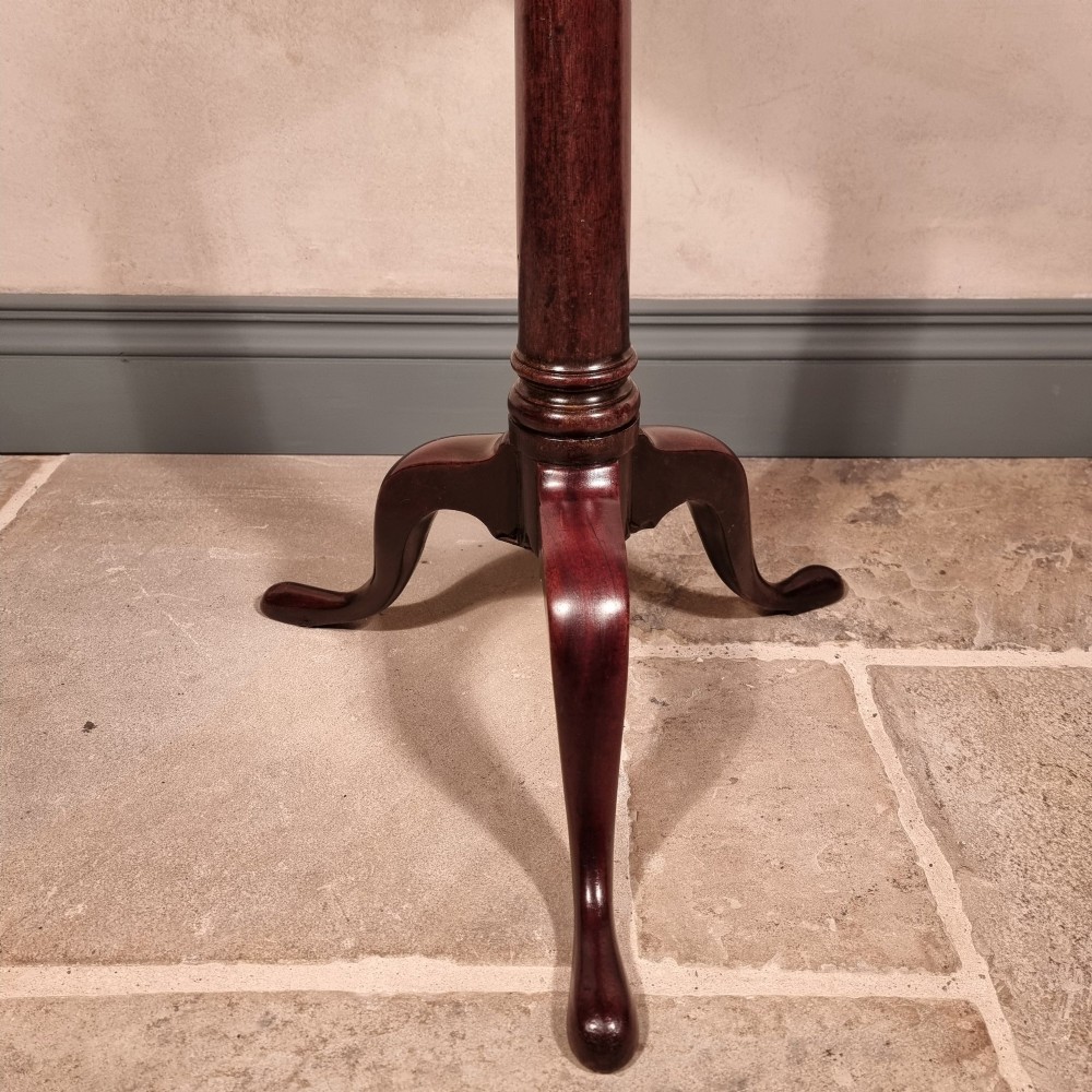 A dark mahogany 18th-century wine table featuring a circular top, turned central pedestal, and three cabriole tripod legs. View IV