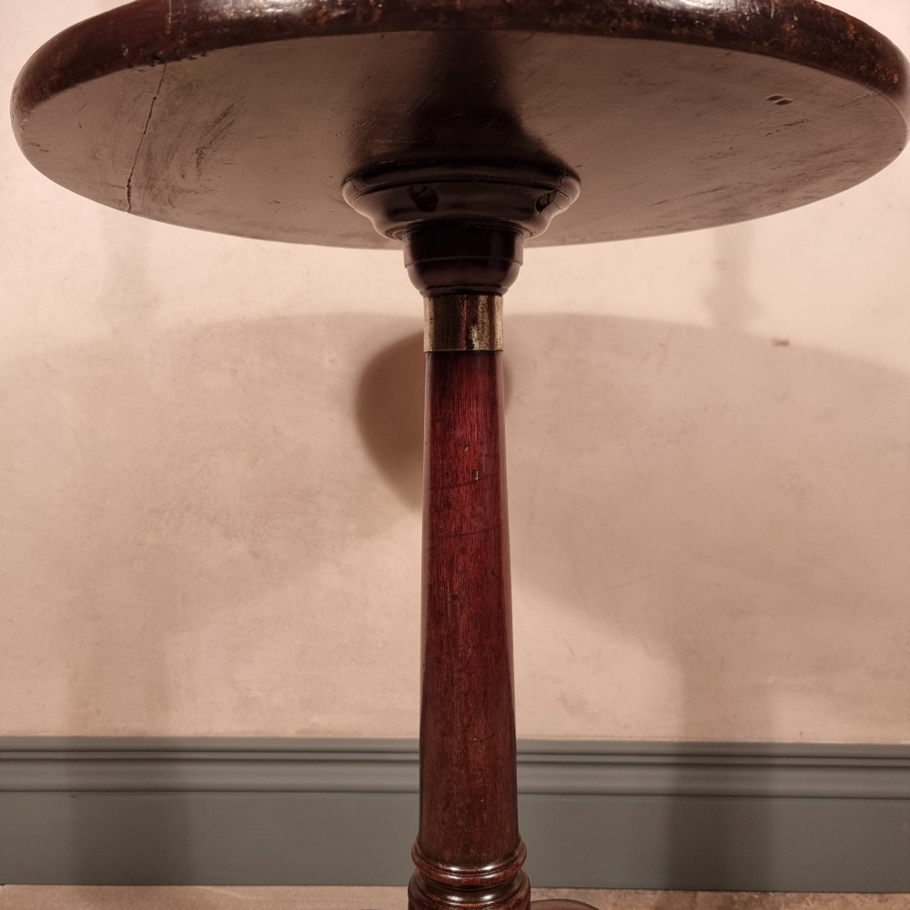 A dark mahogany 18th-century wine table featuring a circular top, turned central pedestal, and three cabriole tripod legs. View V