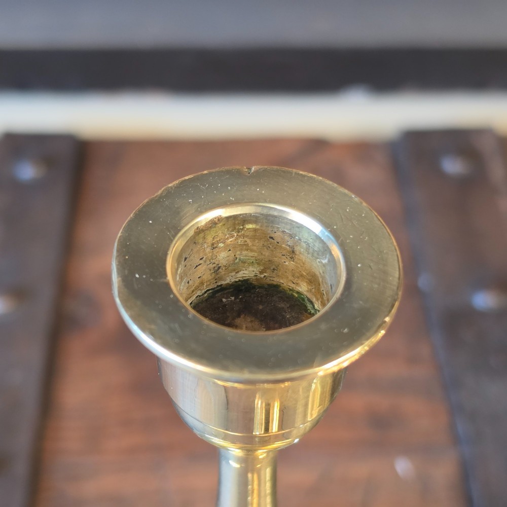A pair of 19th-century turned brass candlesticks featuring wide circular drip pans and stepped bases. View II