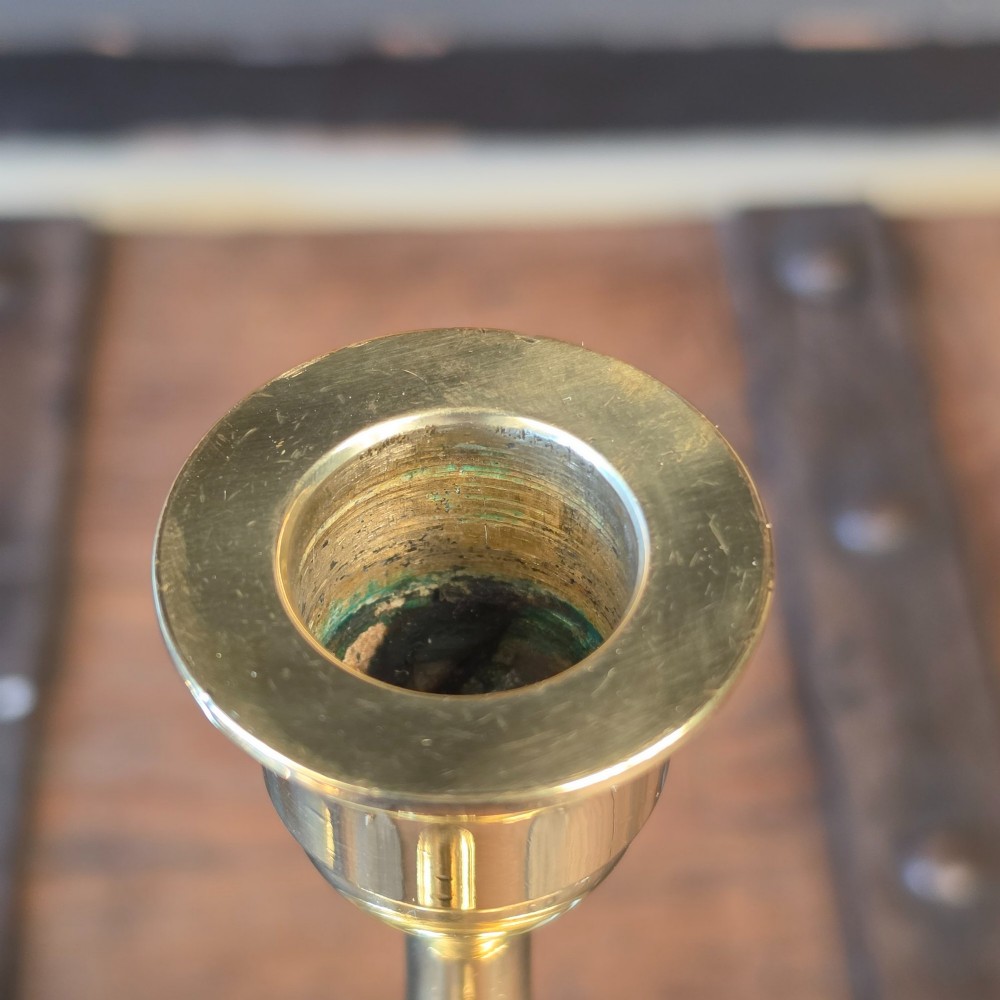 A pair of 19th-century turned brass candlesticks featuring wide circular drip pans and stepped bases. View III