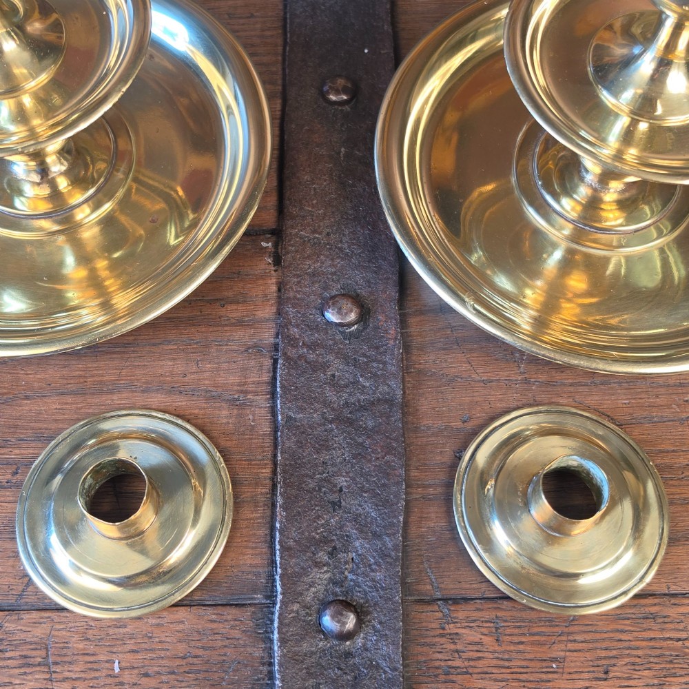 A pair of 19th-century turned brass candlesticks featuring wide circular drip pans and stepped bases. View IV