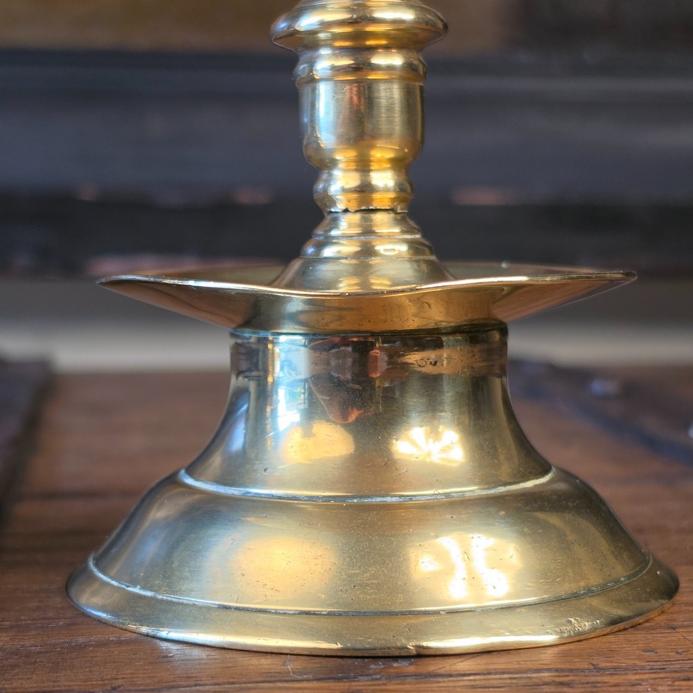 A pair of small turned brass candlesticks featuring flared circular bases, baluster stems, and sockets with wax removal holes. View IV