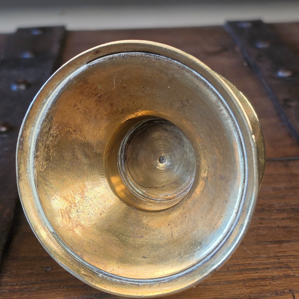 A pair of small turned brass candlesticks featuring flared circular bases, baluster stems, and sockets with wax removal holes. View IX