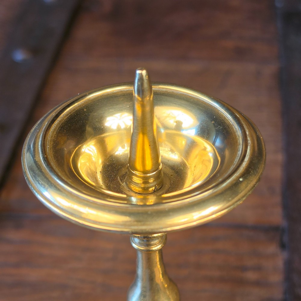 A pair of brass pricket candlesticks featuring central spikes, circular drip pans, baluster-turned stems, and stepped bases. View III