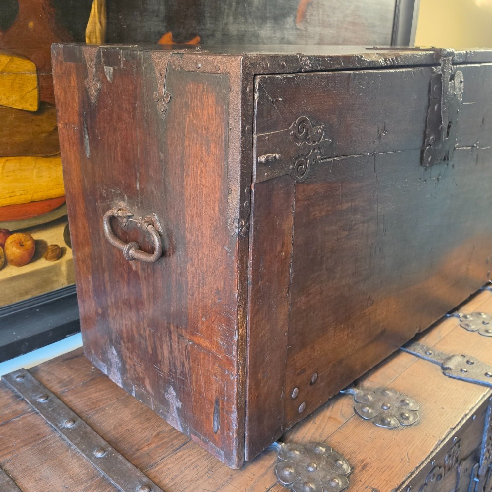 A seventeenth-century dark walnut fall-front table cabinet featuring multiple drawers decorated with intricate geometric and scrollwork wood inlays around an architectural central door. View V