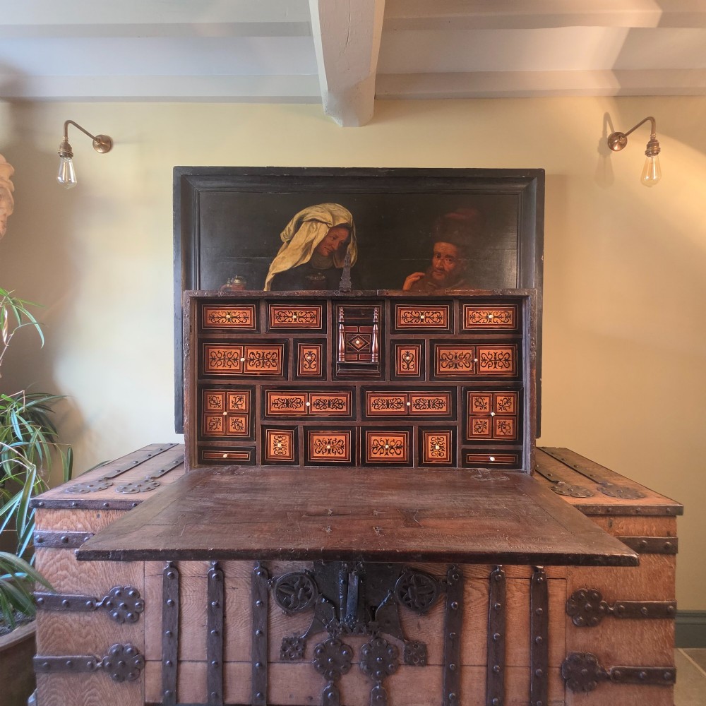 A seventeenth-century dark walnut fall-front table cabinet featuring multiple drawers decorated with intricate geometric and scrollwork wood inlays around an architectural central door. View VIII