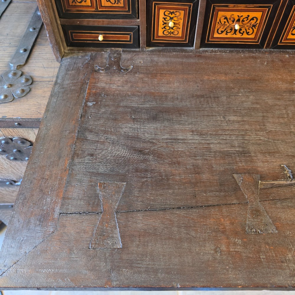 A seventeenth-century dark walnut fall-front table cabinet featuring multiple drawers decorated with intricate geometric and scrollwork wood inlays around an architectural central door. View XI
