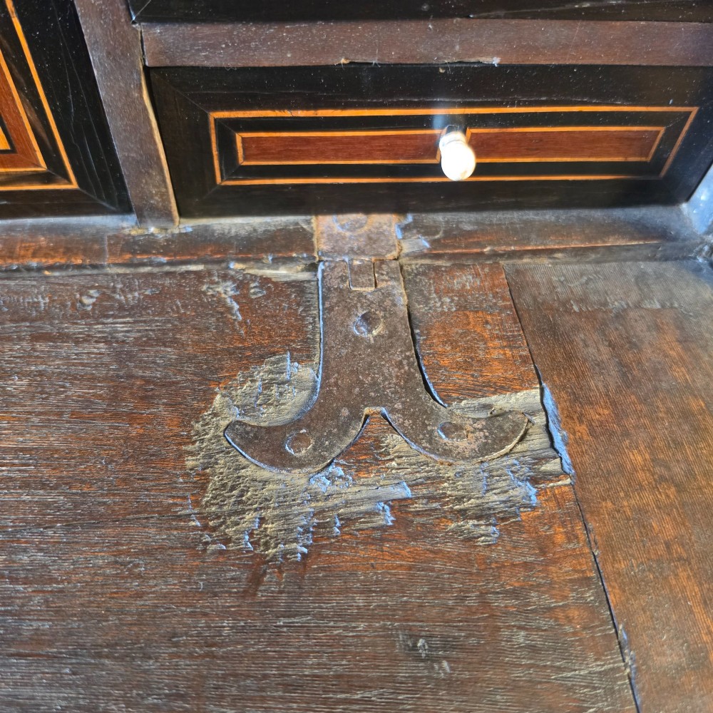 A seventeenth-century dark walnut fall-front table cabinet featuring multiple drawers decorated with intricate geometric and scrollwork wood inlays around an architectural central door. View XIV