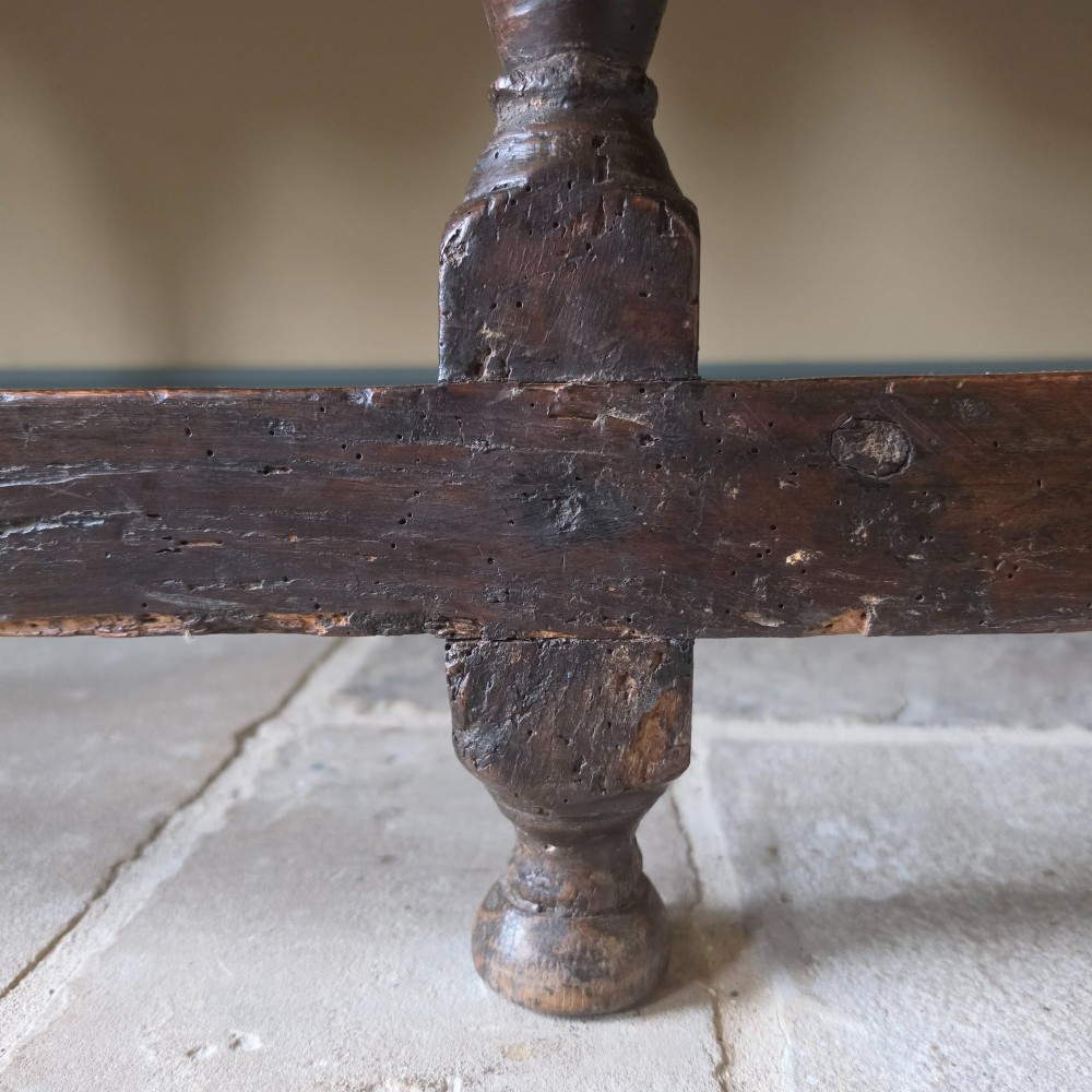 A long 17th-century dark oak dresser base featuring geometric moulded drawers, turned legs, and a shaped apron. View VI