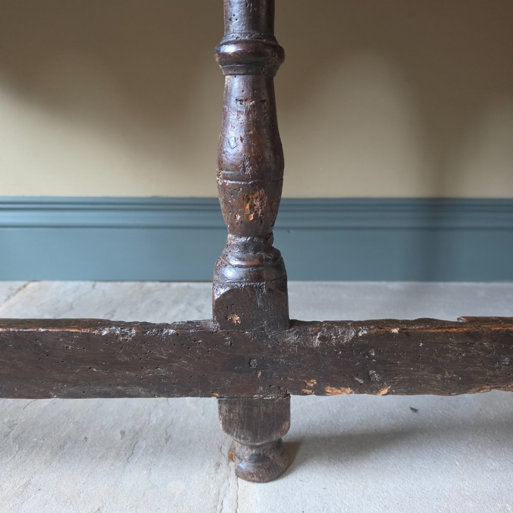 A long 17th-century dark oak dresser base featuring geometric moulded drawers, turned legs, and a shaped apron. View VII