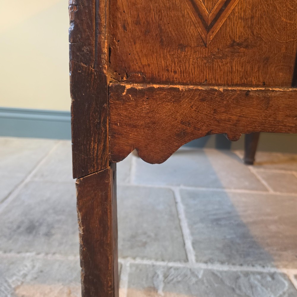A 17th century dark oak food hutch with carved diamond lozenge doors and turned front legs. View XIII