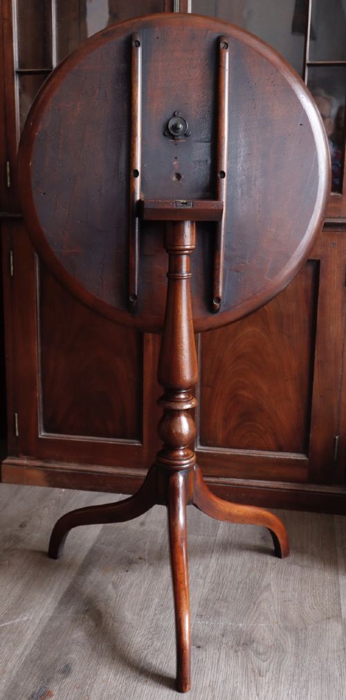fig 1. A mahogany tilt-top tripod table featuring a circular dished top, turned central column, and three cabriole legs.