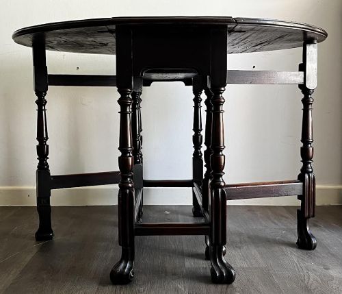 fig 1. A dark mahogany Georgian drop flap dining table with turned gatelegs and feet.
