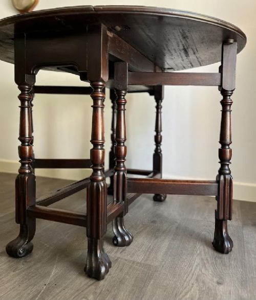 A dark mahogany Georgian drop flap dining table with turned gatelegs and feet. View IV