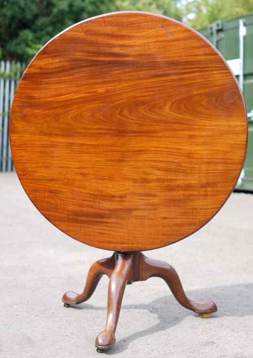 fig 1. A circular mahogany tripod table featuring a turned baluster stem supported by three cabriole legs.