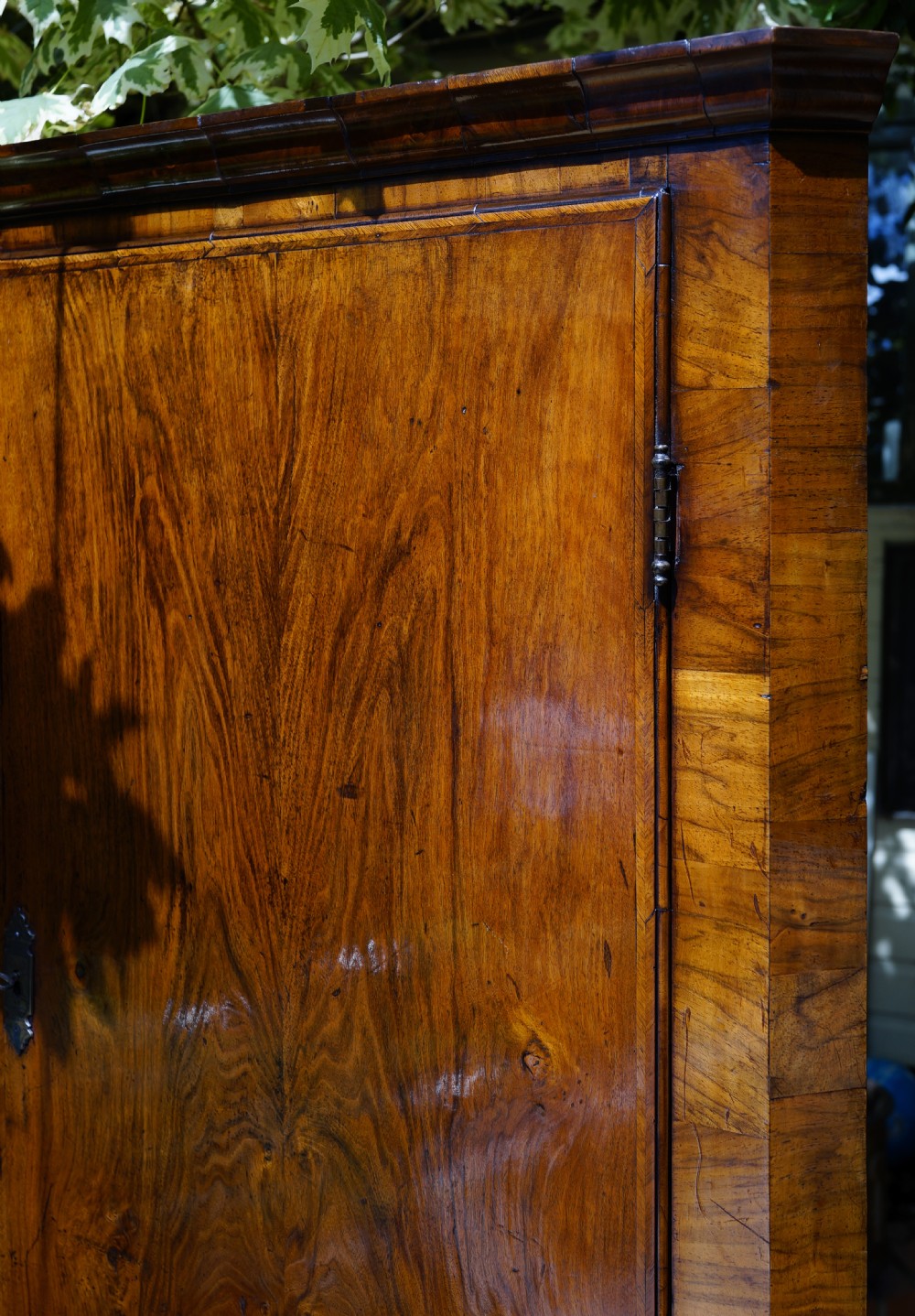 A George II hanging corner cupboard constructed from figured walnut veneer featuring a single door and a brass escutcheon plate. View IV