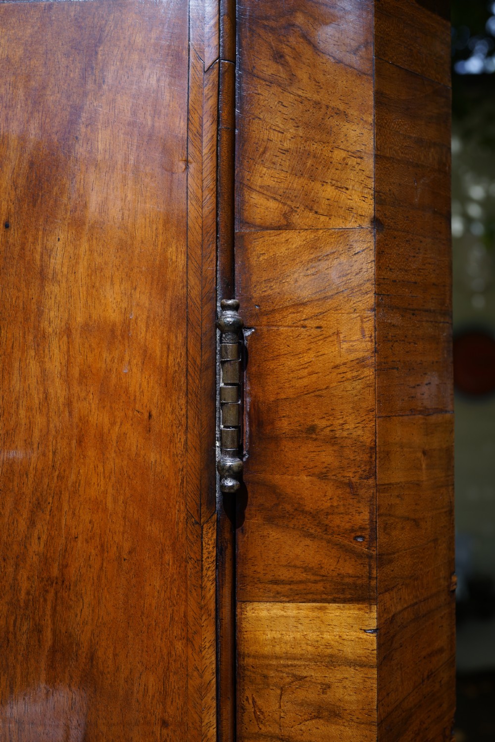 A George II hanging corner cupboard constructed from figured walnut veneer featuring a single door and a brass escutcheon plate. View VI