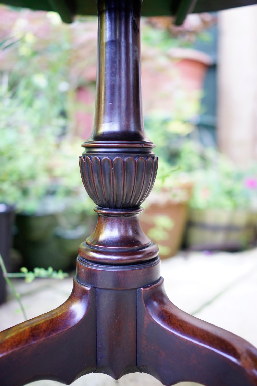 A Georgian mahogany tripod table featuring a circular top, turned carved column, and three cabriole legs. View VII