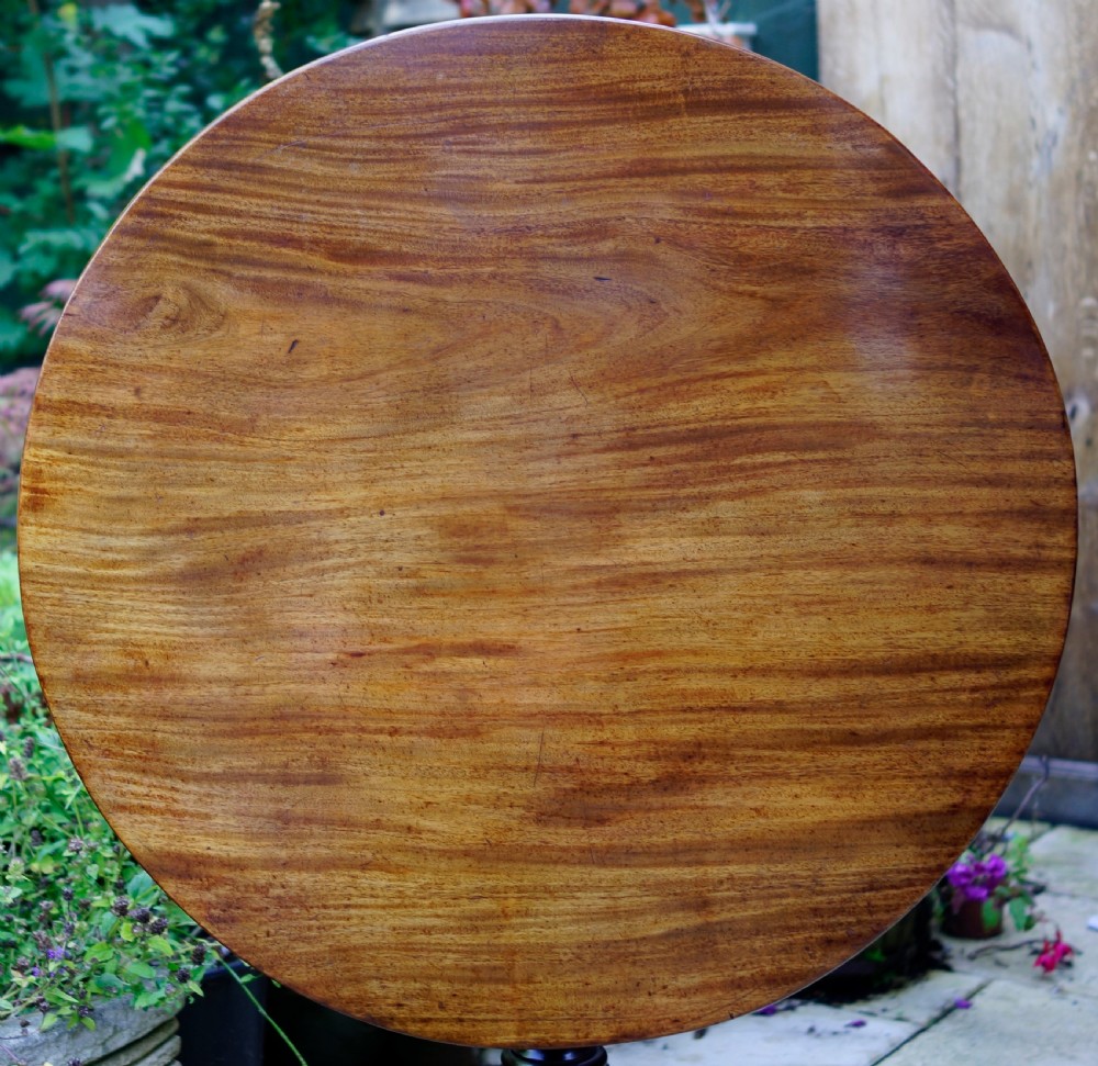 A Georgian mahogany tripod table featuring a circular top, turned carved column, and three cabriole legs. View IX