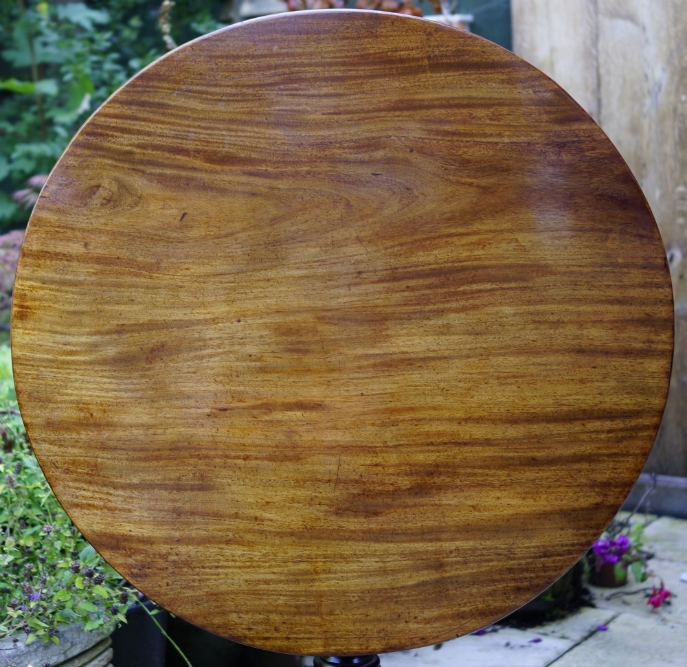 A Georgian mahogany tripod table featuring a circular top, turned carved column, and three cabriole legs. View V