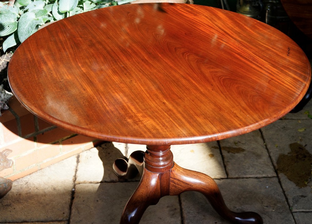 A Georgian mahogany tripod table featuring a circular top, turned central column, and three cabriole legs ending in pad feet. View II