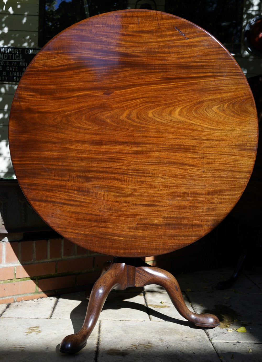 A Georgian mahogany tripod table featuring a circular top, turned central column, and three cabriole legs ending in pad feet. View III