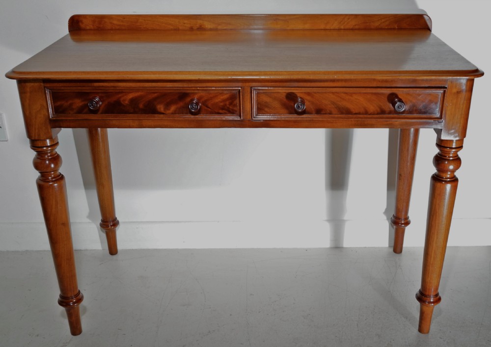 Victorian 1860s mahogany table with two drawers supported on four turned tapering legs.