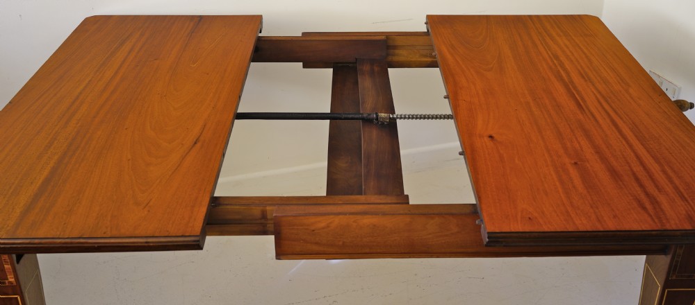 1900s extending wind-out mahogany inlaid dining table on square tapering legs. View II