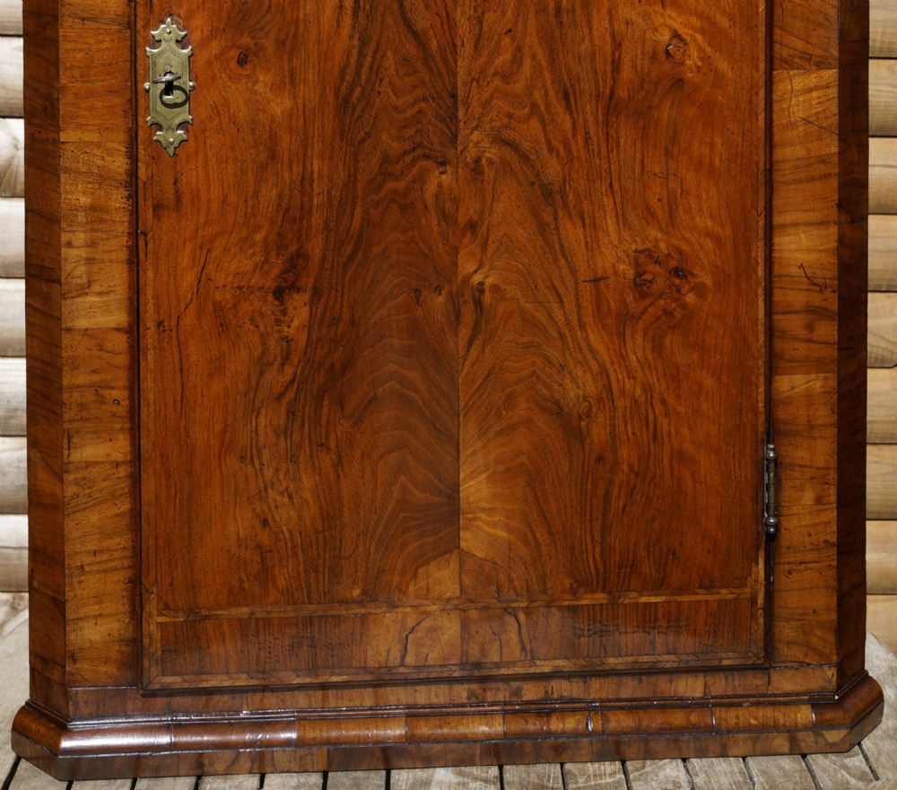 A George II hanging corner cupboard constructed from figured walnut veneer featuring a single door and a brass escutcheon plate. View III