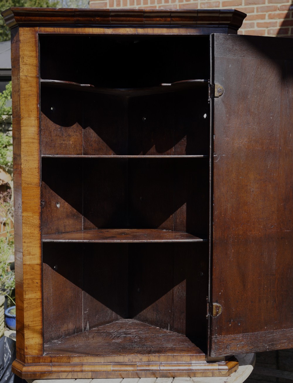 A George II hanging corner cupboard constructed from figured walnut veneer featuring a single door and a brass escutcheon plate. View VIII