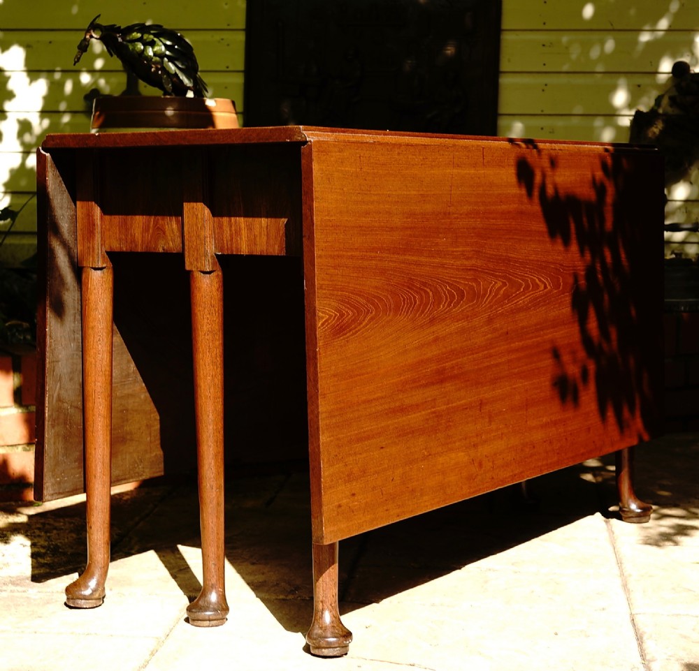 A George III mahogany drop leaf dining table with six tapered legs terminating in pad feet. View III