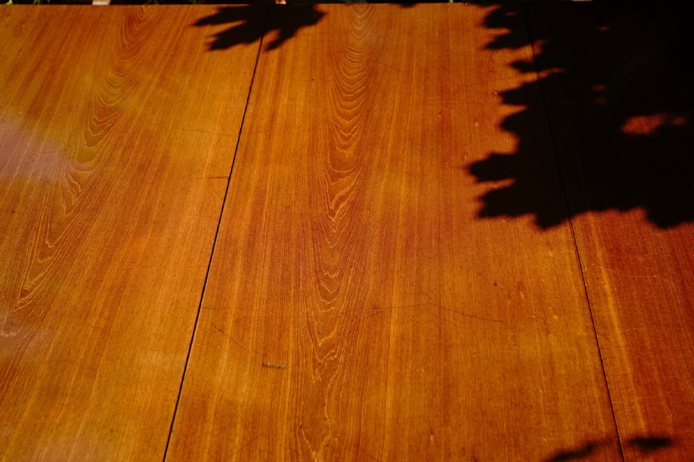 A George III mahogany drop leaf dining table with six tapered legs terminating in pad feet. View V