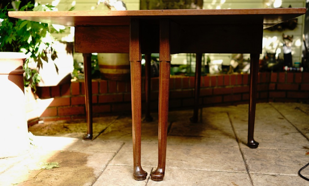 A George III mahogany drop leaf dining table with six tapered legs terminating in pad feet. View VI