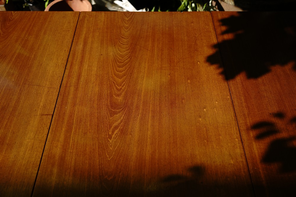 A George III mahogany drop leaf dining table with six tapered legs terminating in pad feet. View VIII