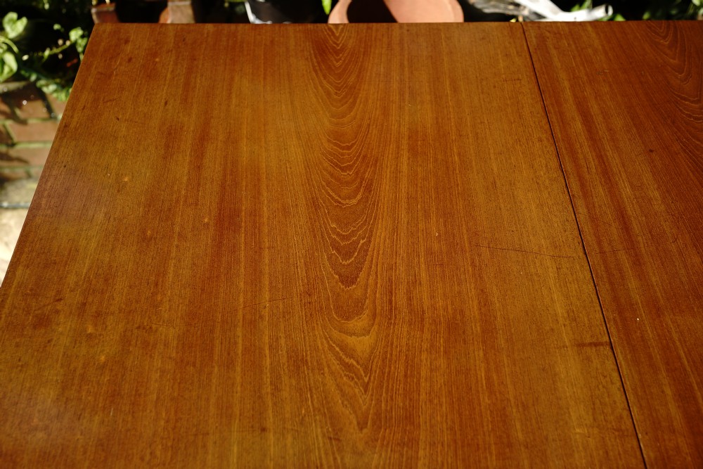 A George III mahogany drop leaf dining table with six tapered legs terminating in pad feet. View IX