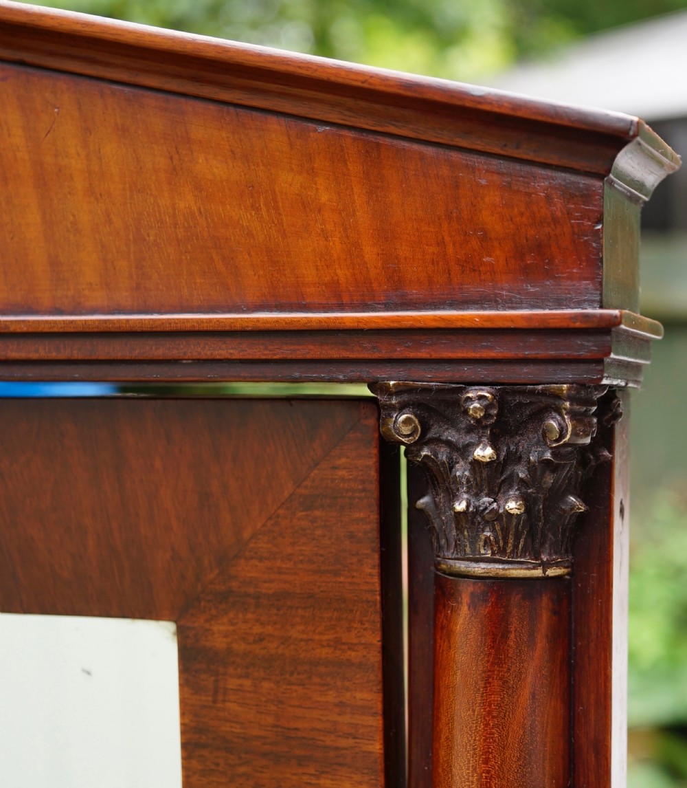 A Victorian mahogany swing dressing mirror featuring a pediment top decorated with a brass mount, side columns, and a single drawer base. View VI
