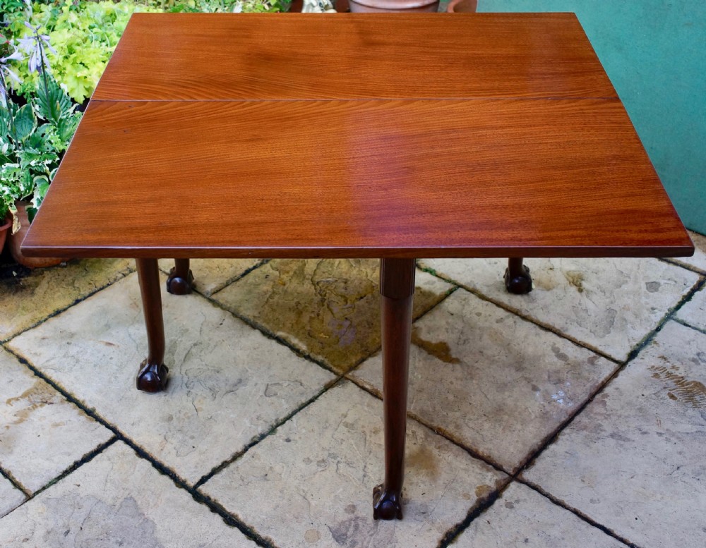 An eighteenth-century mahogany drop leaf table with a polished rectangular top, turned legs, and hand-carved claw and ball feet. View II