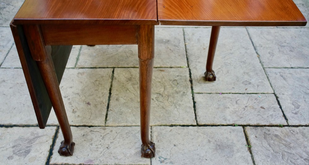 An eighteenth-century mahogany drop leaf table with a polished rectangular top, turned legs, and hand-carved claw and ball feet. View III
